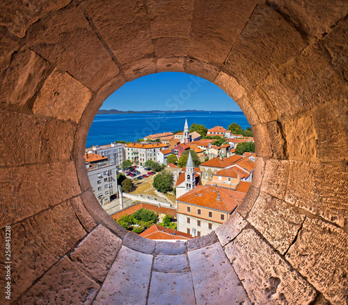 Colorful city of Zadar rooftops and towers view through stone window