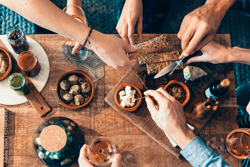 high angle view of hands picking up food from a table: togetherness, friendship, appetizer, aperitif, tapas moment concept