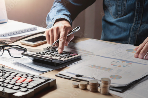 businessman working in office with using a calculator to calculate the numbers finance accounting concept