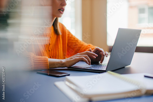 Close up of female hands typing text on laptop, Business woman using laptop while communicating with a business partner in co-working place