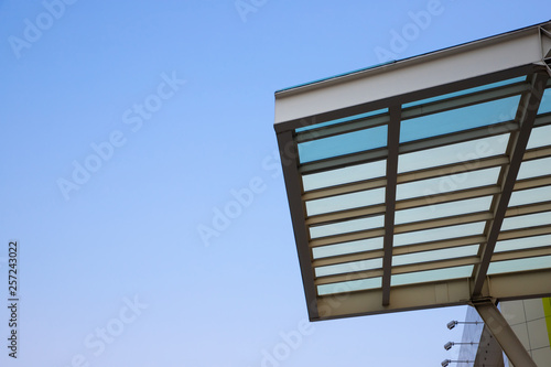 transparent roof and steel structure with clear blue sky background. shading for building, exterior decoration, car park lot or out door walk way path