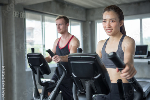 Young couple sport exercise with elliptical machine in gym . fitness man and woman workout together ,training,