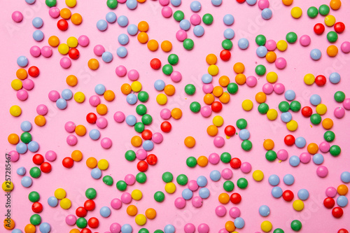 Birthday concept. Colorful round candies on pink background