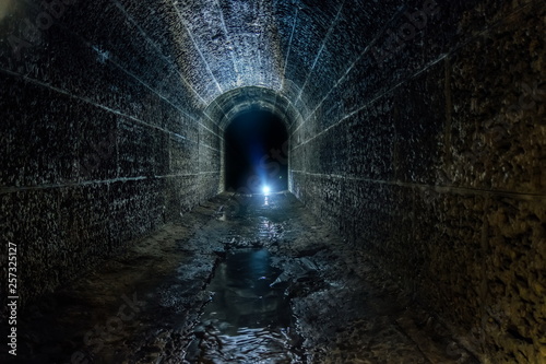 Dark and creepy old historical vaulted flooded underground drainage tunnel