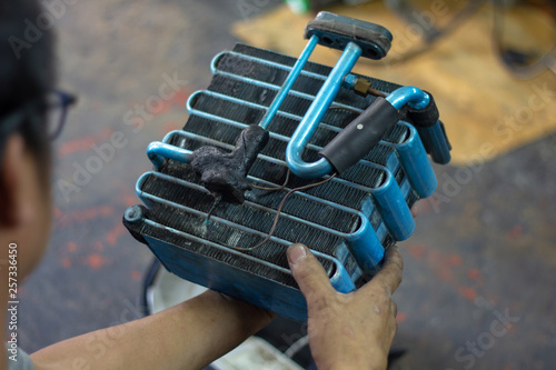 Car air conditioner evaporator coil close up. Auto mechanic worker fixing air condition in car garage..Maintenance service, Repair checking vehicle engine tools car air conditioner system.