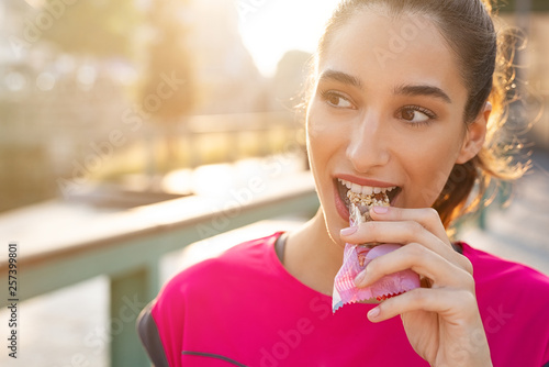 Sporty woman eating energy bar