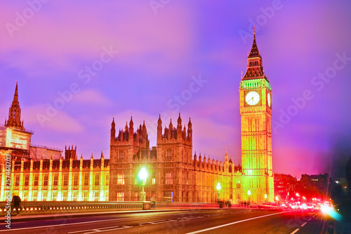 View of the Houses of Parliament and Westminster Bridge along River Thames in London at night.