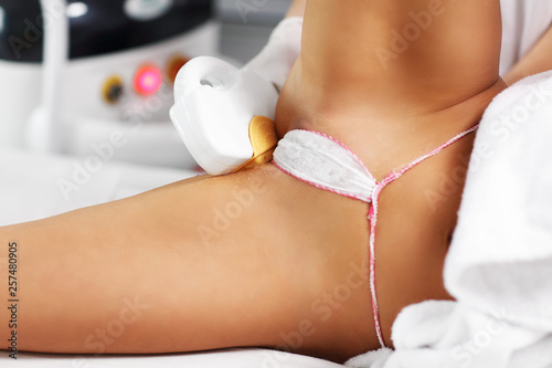Beautician Giving Epilation Laser Treatment To Woman On Bikini