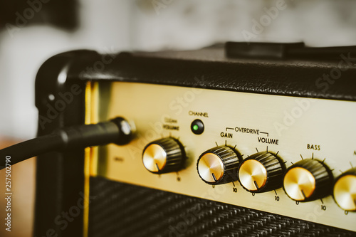 Guitar electric amplifier. Rock music overdrive effect. Volume control knob up to the max. Shallow depth of field