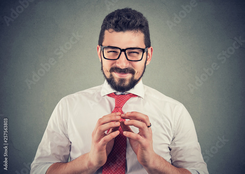 Sly businessman in glasses looking at camera plotting a revenge