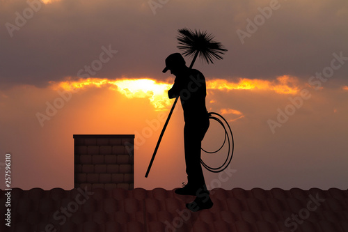 chimney sweep on roof at sunset