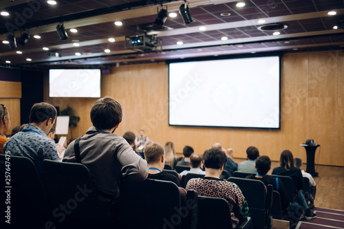 Speaker giving a talk in conference hall at business event. Audience at the conference hall