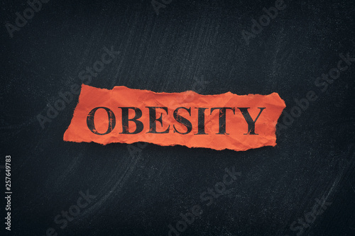 Word Obesity on red torn piece of paper