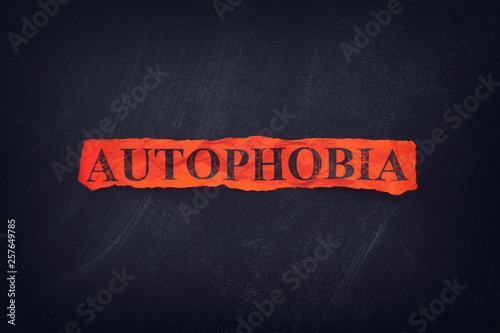 Word Autophobia on red torn piece of paper