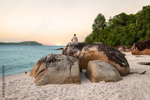 Man Meditating and doing Yoga Exercises on beach