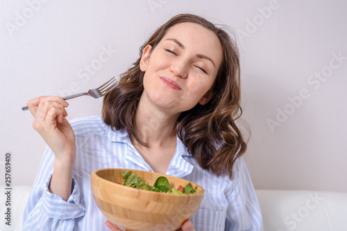 close up of woman eating healthy vegetable salad with pleasure