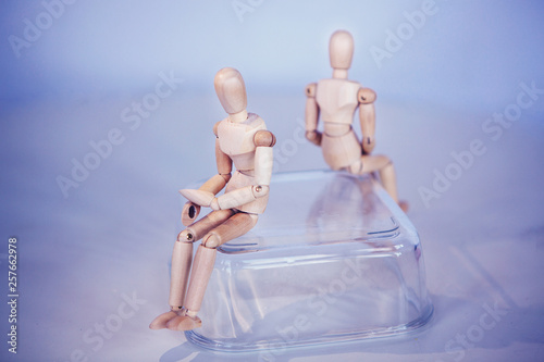 Creative concept. Conflict of interest. Wooden men sits on opposite sides.Misunderstanding. Selfishness.