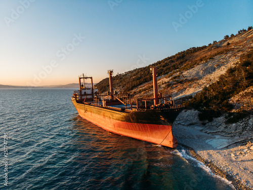 Cargo ship run aground at sea coastline near Novorossiysk and Gelendzhik. Shipwreck accident of nautical vessel after huge sea storm, aerial view