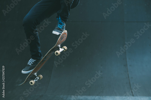 Urban skater in action. Ollie trick. Skate park ramp. City area. Man on skateboard jumping. Copy space for text.