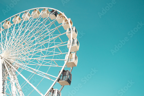 Big city ferris wheel on a background of clean blue sky