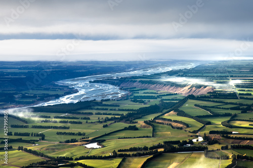 Wide open view over landscape. Patchwork like fields and winding blue river. Canterbury plains landscape. beautiful landscape background. new Zealand outdoors and adventure.