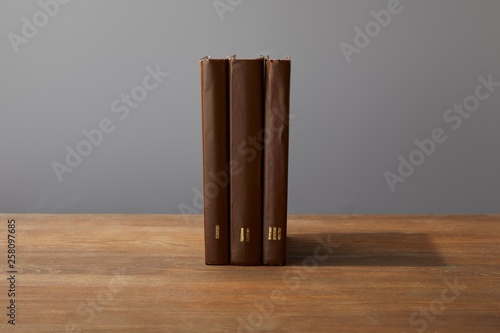 Brown books on textured wooden surface isolated on grey