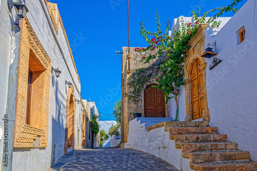 Beautiful scenic narrow wavy streets with ancient white houses and flowers. Famous tourist destination in South Europe.