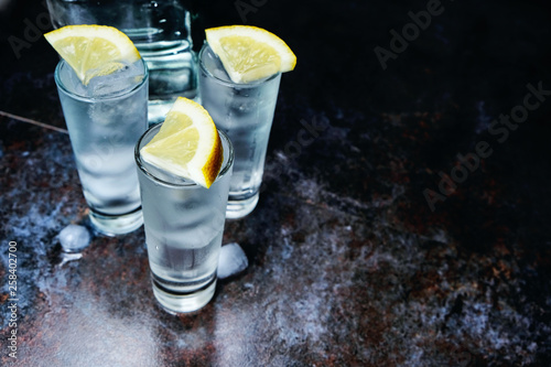 Vodka. Shots, glasses with vodka with ice .Dark stone background.Copy space .Selective focus