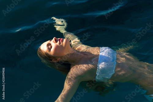 Young girl swimming on her back