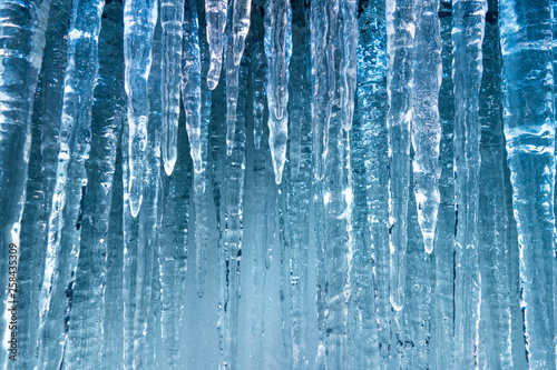 pure clear blue hanging ice sickles in winter cold background