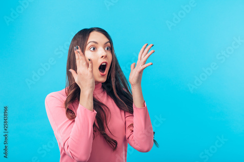 Shocked amazing woman isolated on blue background