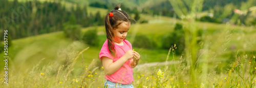 funny little happy girl on the mountain top. Freedom, little girl playing on meadow. Travel, lifestyle concept