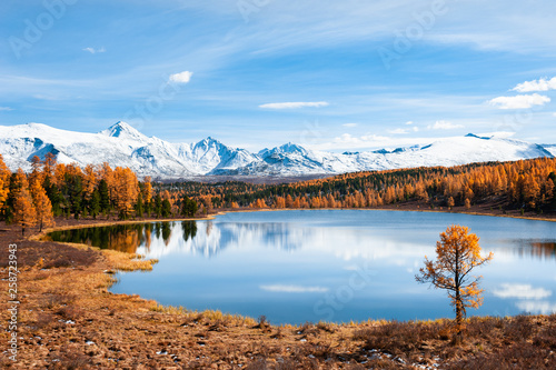 Kidelu lake in autumn forest and snow-covered mountains in Altai, Siberia, Russia