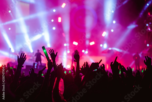 silhouettes of hand in concert.Light from the stage.