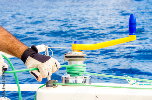 Mano con guante mitón con aparejo y cuerda de barco yate velero