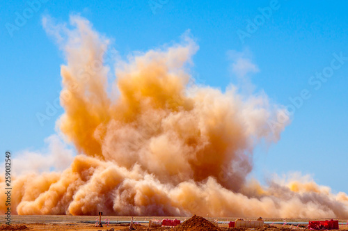 Rock dust clouds after the detonator blast on the mining site 