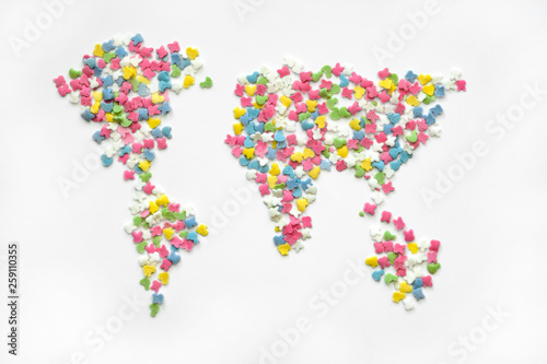 Colorful sugar sprinkles in world map shap on a white backgrounde, top view. Creative collection