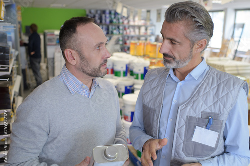 shop assistant giving advice to customer in hardware store