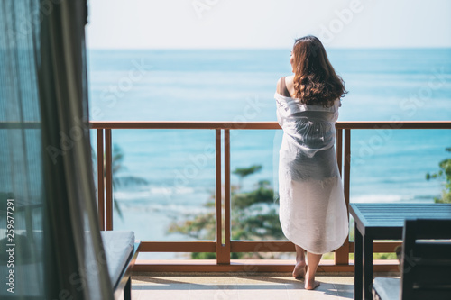 A beautiful asian woman standing and enjoy watching the sea view at balcony