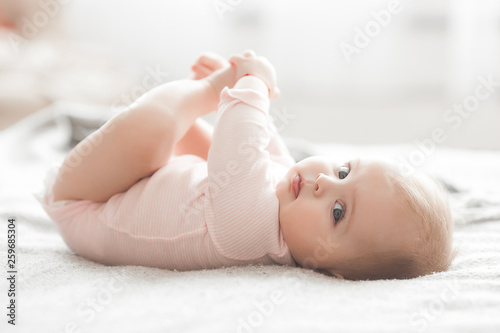Adorable little baby portrait. Cute baby girl indoor. 6 month child smiling.