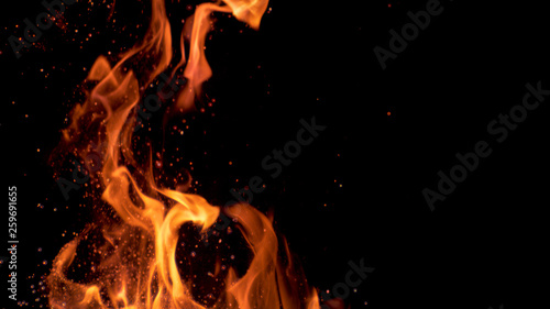 MACRO: Beautiful bright orange flames flicker in the darkness of the night.