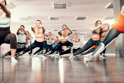 Group of Caucasian cheerful women standing in gym and doing stretching exercises. For good thing sin life takes time and persistence.