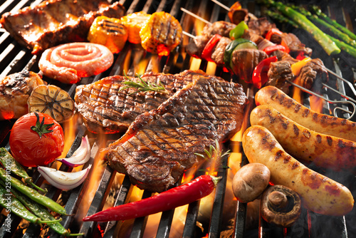 Delicious grilled meat with vegetables sizzling over the coals on barbecue