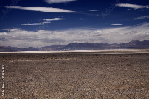 View over endless dried barren land on blurred mountain range in the horizon - Maricunga Salt flat plateau near San Pedro de Atacama, Chile