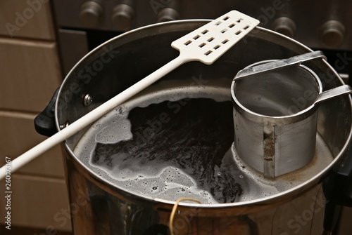 A man brewing craft beer in a kitchen. Home brewing concept image. 