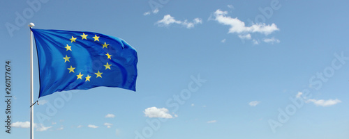 EU flag waving against blue sky with clouds. Copy space