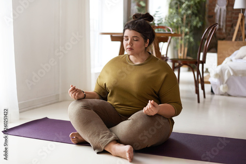 Young woman meditating at home