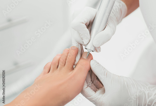 Podolog removes the cuticle on the nails using hardware.