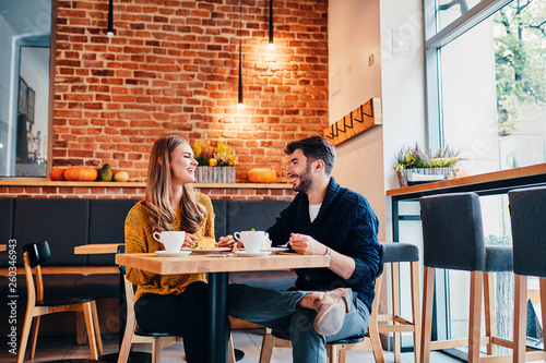 Picture of young couple dating at cafe. Young woman and man at coffee shop.