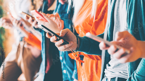 Millennials in digital age. Cropped closeup of smartphones in young people hands. Youth addicted to social networking services.